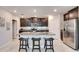 Modern kitchen with island, granite counters, and dark cabinets at 5328 Stoic Vale Dr, Wimauma, FL 33598