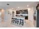 Modern kitchen with island, granite counters, and dark cabinets at 5328 Stoic Vale Dr, Wimauma, FL 33598