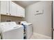 Laundry room with washer, dryer, and overhead cabinets at 5328 Stoic Vale Dr, Wimauma, FL 33598