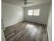 Well-lit bedroom with wood-look floors and window coverings at 883 Sky Loch S Dr, Dunedin, FL 34698