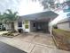 Front view of a house with a lime green door and carport at 883 Sky Loch S Dr, Dunedin, FL 34698