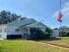 Light teal 55+ community building with flag and palm trees at 883 Sky Loch S Dr, Dunedin, FL 34698