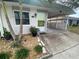Front view of a house with a lime green door and landscaping at 883 Sky Loch S Dr, Dunedin, FL 34698