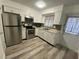 Bright kitchen with stainless steel appliances and wood-look floors at 883 Sky Loch S Dr, Dunedin, FL 34698