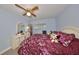 King-size bed, dresser and ceiling fan in bedroom at 102 Cambridge Trl # 225, Sun City Center, FL 33573