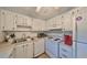 Bright kitchen features white cabinets, and appliances at 102 Cambridge Trl # 225, Sun City Center, FL 33573