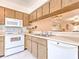 Kitchen with white appliances and wood cabinets at 1447 Water View W Dr, Largo, FL 33771