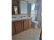 Bathroom with double vanity, toilet and shelving at 1463 Bobolink St, Zephyrhills, FL 33540