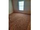 Simple bedroom with brown patterned carpet and window at 1463 Bobolink St, Zephyrhills, FL 33540