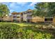 Condo building with green lawn and mature trees at 1550 S Belcher Rd # 117, Clearwater, FL 33764