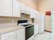 Bright kitchen featuring white cabinets and tile floors at 15505 Granby Pl, Tampa, FL 33624