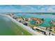 Wide aerial showcasing waterfront home, beach, and high-rises at 1613 Sand Key Estates Ct, Clearwater, FL 33767