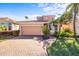 Two-story house with a beige exterior, a two-car garage, and a well-manicured lawn at 1613 Sand Key Estates Ct, Clearwater, FL 33767