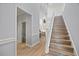 Light wood staircase with a half-bath visible down the hallway at 1613 Sand Key Estates Ct, Clearwater, FL 33767