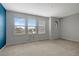 Bedroom with three windows, blue accent wall, and carpet at 19354 Yellow Clover Dr, Tampa, FL 33647