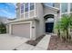 House entrance with a three-car garage and dark blue front door at 19354 Yellow Clover Dr, Tampa, FL 33647