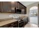 Modern kitchen with dark cabinetry, granite countertops, and stainless steel appliances at 19354 Yellow Clover Dr, Tampa, FL 33647