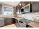Modern kitchen features dark wood cabinets, granite countertops, and stainless steel appliances at 19354 Yellow Clover Dr, Tampa, FL 33647