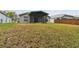 Home's backyard with covered patio and grassy lawn at 25406 Lexington Oaks Blvd, Wesley Chapel, FL 33544