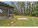 Landscaped backyard with screened porch and wooded backdrop at 25406 Lexington Oaks Blvd, Wesley Chapel, FL 33544