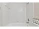 Simple bathroom with white tiled walls, bathtub, and shower fixture at 25406 Lexington Oaks Blvd, Wesley Chapel, FL 33544