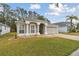 House exterior featuring a two-car garage and well-manicured lawn at 25406 Lexington Oaks Blvd, Wesley Chapel, FL 33544