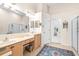 Double vanity bathroom with walk-in shower and access to bedroom at 27325 Mistflower Dr, Wesley Chapel, FL 33544
