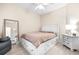 Bright bedroom with a queen-size bed, dresser, and mirror at 27325 Mistflower Dr, Wesley Chapel, FL 33544