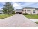 Brick driveway and garage of a tan house at 27325 Mistflower Dr, Wesley Chapel, FL 33544