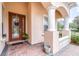 Inviting front porch with brick flooring, arched entryway, and decorative columns at 27325 Mistflower Dr, Wesley Chapel, FL 33544