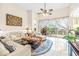 Relaxing living room with light beige sofas, coffee table, and patio access at 27325 Mistflower Dr, Wesley Chapel, FL 33544