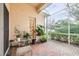 Screened porch with brick flooring and potted plants at 27325 Mistflower Dr, Wesley Chapel, FL 33544