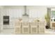 Modern kitchen with white cabinets and an island with four bar stools at 31537 Cardinal Yard Dr, San Antonio, FL 33576