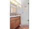 Bathroom with granite countertop, wood cabinets and a shower at 5012 Starfish Se Dr # C, St Petersburg, FL 33705