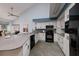 Modern kitchen with white cabinets, granite counters and black appliances at 661 Segovia Ne Ct, St Petersburg, FL 33703