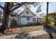 White house with a gable roof, mature trees, and a small front yard at 7408 S Elliott St, Tampa, FL 33616