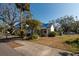 Front view of a white house with a blue tarp on the roof and a sidewalk at 7408 S Elliott St, Tampa, FL 33616