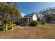 White house with a porch and a blue tarp on the roof, partially visible at 7408 S Elliott St, Tampa, FL 33616