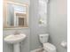 Small bathroom with pedestal sink, toilet, and mirror at 7525 Red Mill Cir, New Port Richey, FL 34653