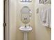 Powder room features pedestal sink and oval mirror at 8841 Walnut Gable Ct, Riverview, FL 33578