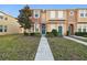 Tan two-story townhome with teal door, American flag, and landscaped lawn at 8841 Walnut Gable Ct, Riverview, FL 33578