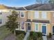 Two-story townhouse exterior, landscaping, and blue door at 8841 Walnut Gable Ct, Riverview, FL 33578