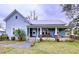 Charming light blue house with a metal roof, porch, and well-manicured lawn at 908 E Gilchrist St, Plant City, FL 33563