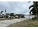 Single story home with driveway and American flag at 9524 Treasure Ne Ln, St Petersburg, FL 33702