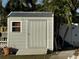 White metal storage shed with single door and window at 9524 Treasure Ne Ln, St Petersburg, FL 33702