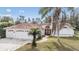 House front with two-car garage and palm trees at 9714 Hermosillo Dr, New Port Richey, FL 34655