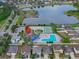 Aerial view showing community pool, tennis courts, and lake at 12017 Gillingham Harbor Ln, Gibsonton, FL 33534