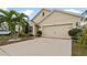House exterior features a two-car garage and well-manicured landscaping at 12017 Gillingham Harbor Ln, Gibsonton, FL 33534