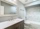 Updated bathroom with gray vanity, marble tile, and bathtub at 1210 Lady Elaine Dr, Valrico, FL 33594