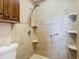 Walk-in shower with tiled walls and convenient shelving at 1210 Lady Elaine Dr, Valrico, FL 33594